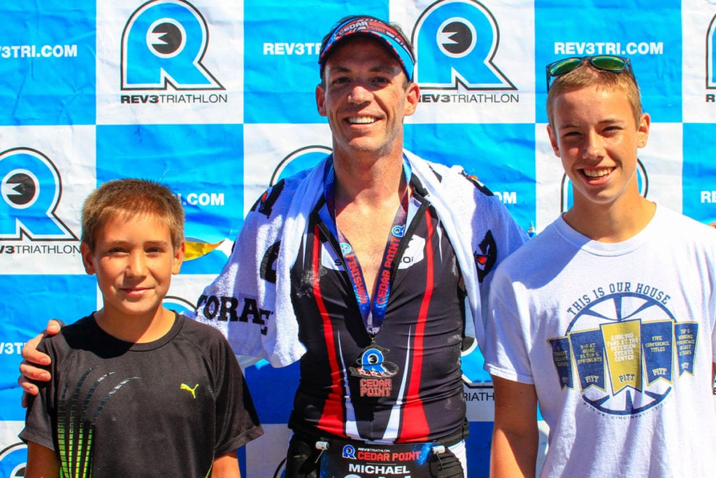 Mike Bauer with two kids and medal