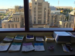 a view from a window at UPMC/Pitt behind stacks of literature on pulmonary hypertension