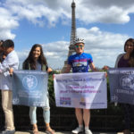 Patty George and friends holding signs in front of the Eiffel Tower in Prais in 2015