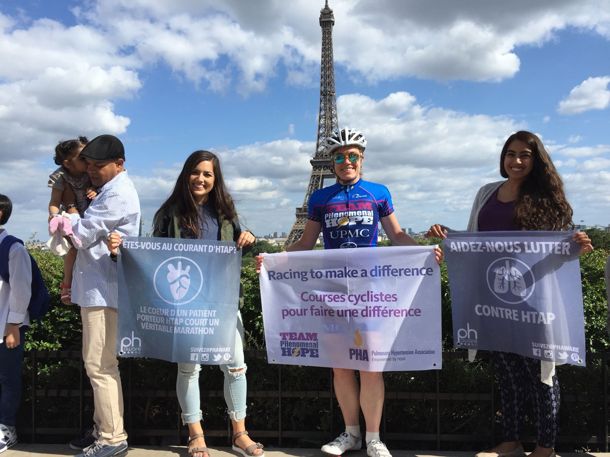 Patty George and friends holding signs in front of the Eiffel Tower in Prais in 2015