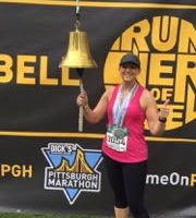 Beth Hamilton smiling after race ringing the bell