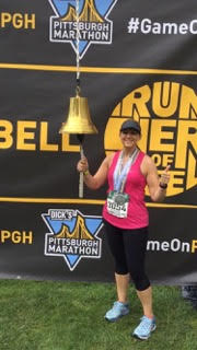 Beth Hamilton smiling after race ringing the bell