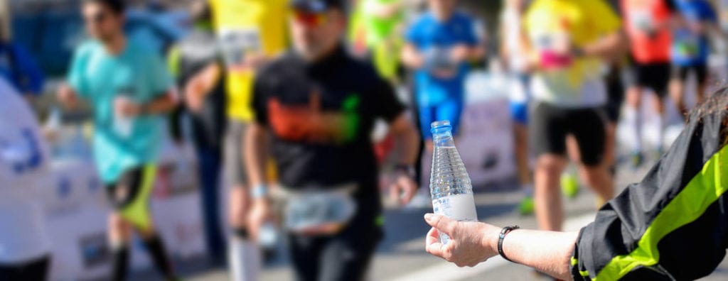 a volunteer handing out water during a footrace