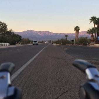view of the road ahead from the perspective of cycling handlebars